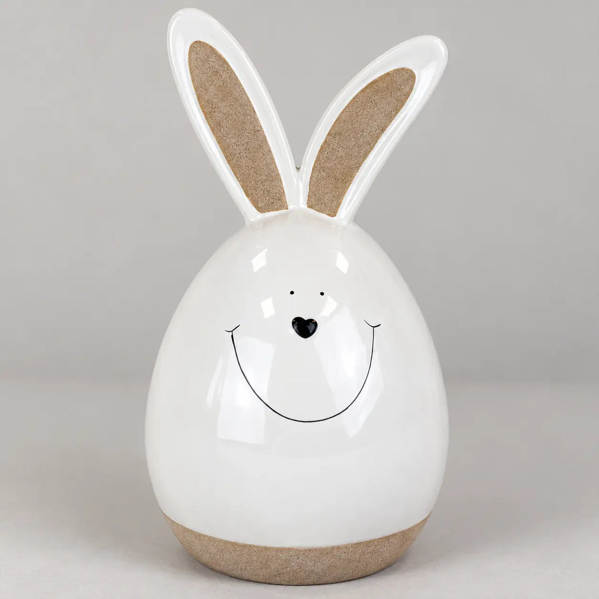 Detail view of the white ceramic rabbit showing its smiling face and beige inner ears.
