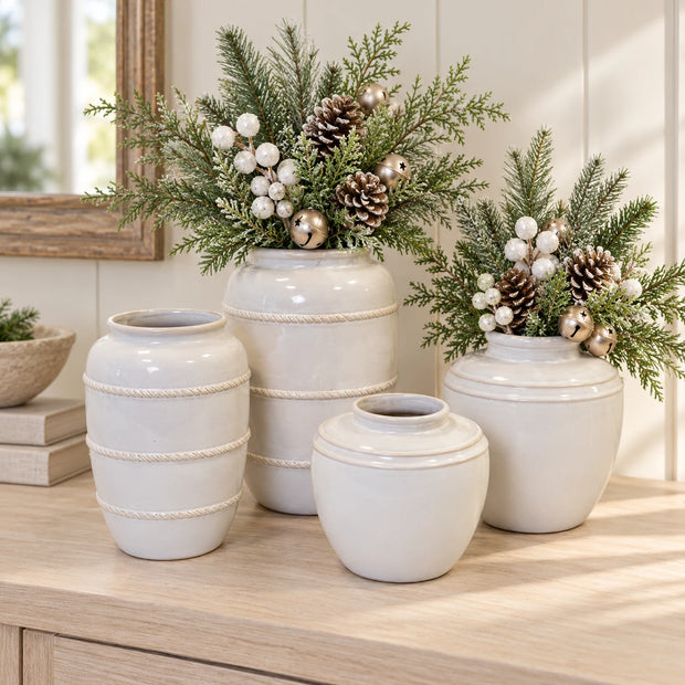 Four white rustic ceramic vase sizes shown together with neutral winter foliage, white berries, bells and pine cones; vases sold separately