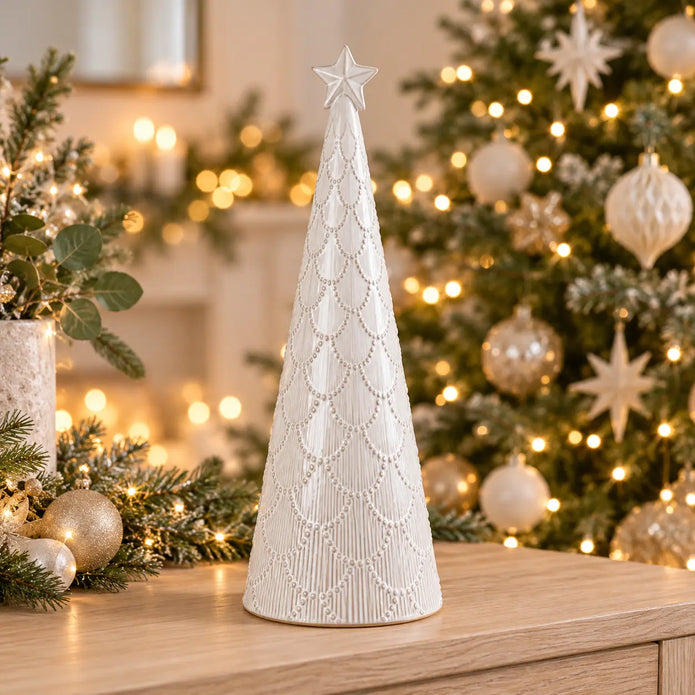 large white scalloped glazed ceramic Christmas tree in a festive Christmas setting with sparkling warm fairy lights