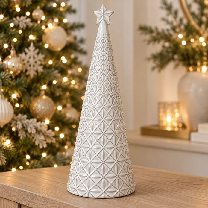 large white star glazed ceramic Christmas tree in a festive setting with warm sparkling Christmas lights