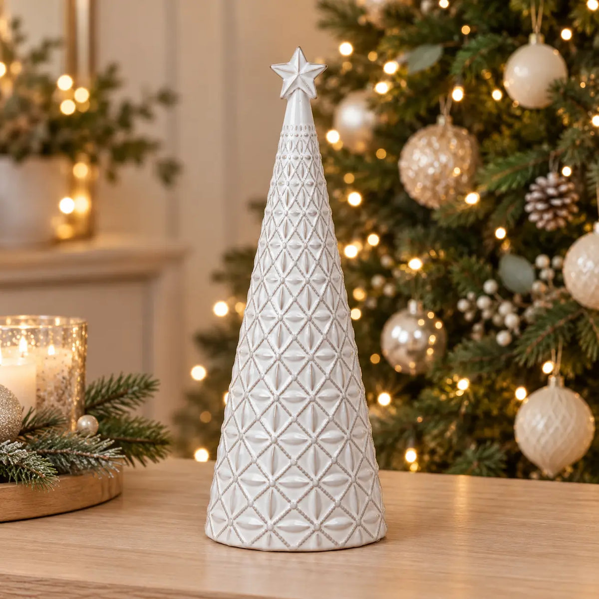 medium white star glazed ceramic Christmas tree in a festive setting with warm sparkling Christmas lights