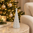 small white star glazed ceramic Christmas tree in a festive setting with warm sparkling Christmas lights