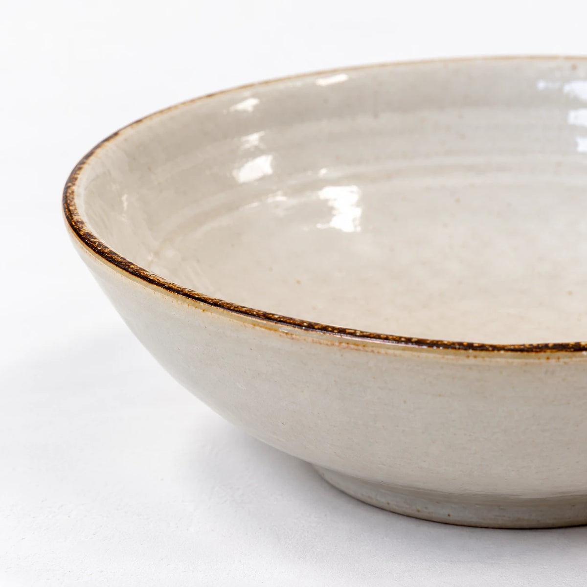 Close-up of the brown rim and white glaze of the stoneware cereal bowl