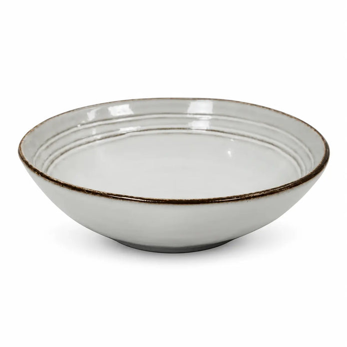 White stoneware pasta bowl with dark brown rim isolated on a white background
