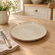 White stoneware side plate with fine brown rim on a pale oak country kitchen table