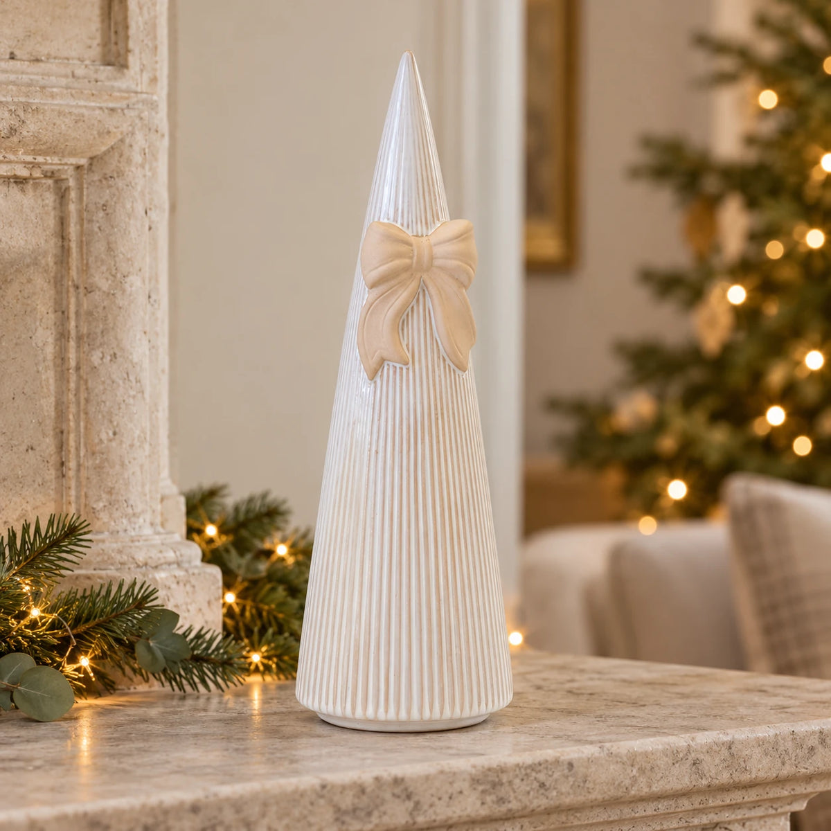 Large Satchville white stoneglazed striped Christmas tree with decorative bow on mantelpiece