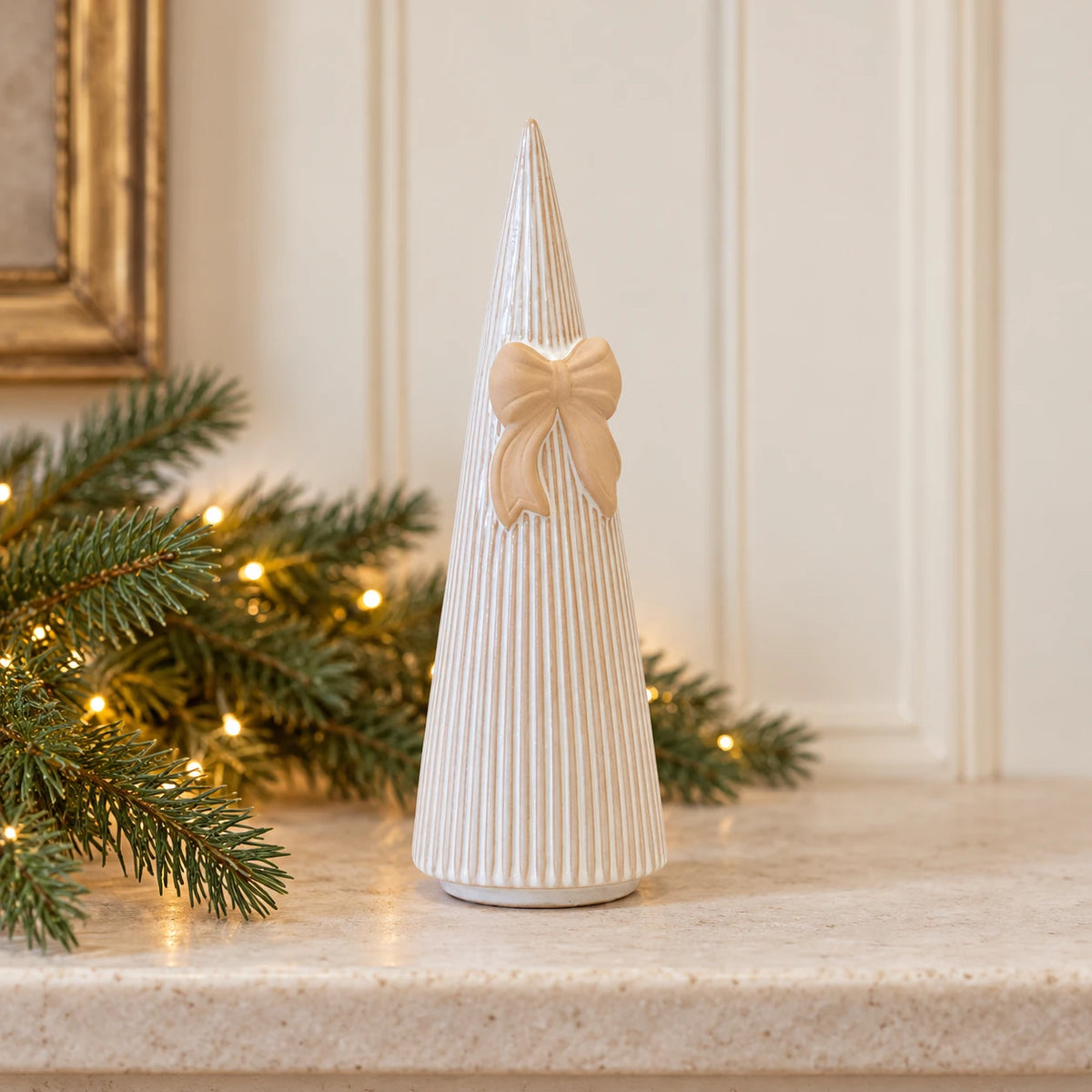 Satchville medium white stoneglazed striped Christmas tree with bow on mantel