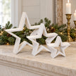 Whitewashed wooden star set on a limestone mantel with festive pine garland