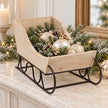 Whitewashed decorative sleigh filled with ivory baubles and greenery, contents not included
