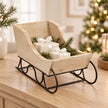 Whitewashed wooden decorative sleigh styled with white-ribbon gifts and fir, contents not included