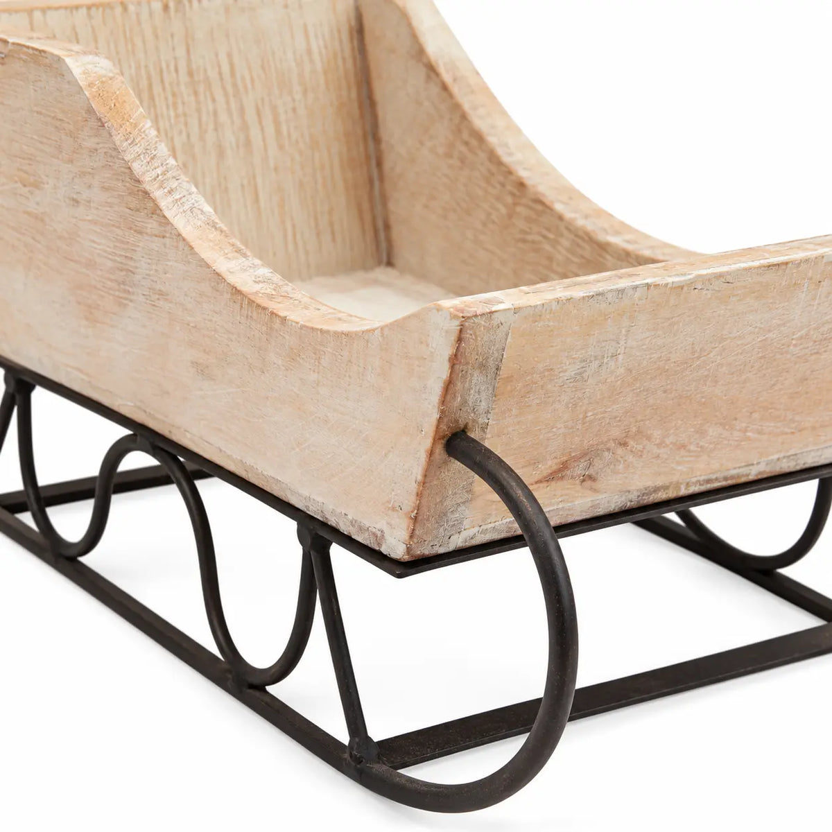 Close-up of whitewashed wood grain and dark metal sleigh runner
