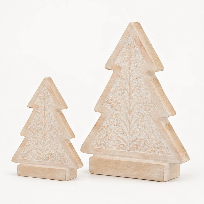 Two sizes of carved whitewashed wooden Christmas trees on a pale background
