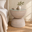 Lows Wickham rattan hourglass side table with glass top beside a bed