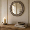 Wickham Rattan Natural Round Mirror, round woven mirror above books and a lit candle