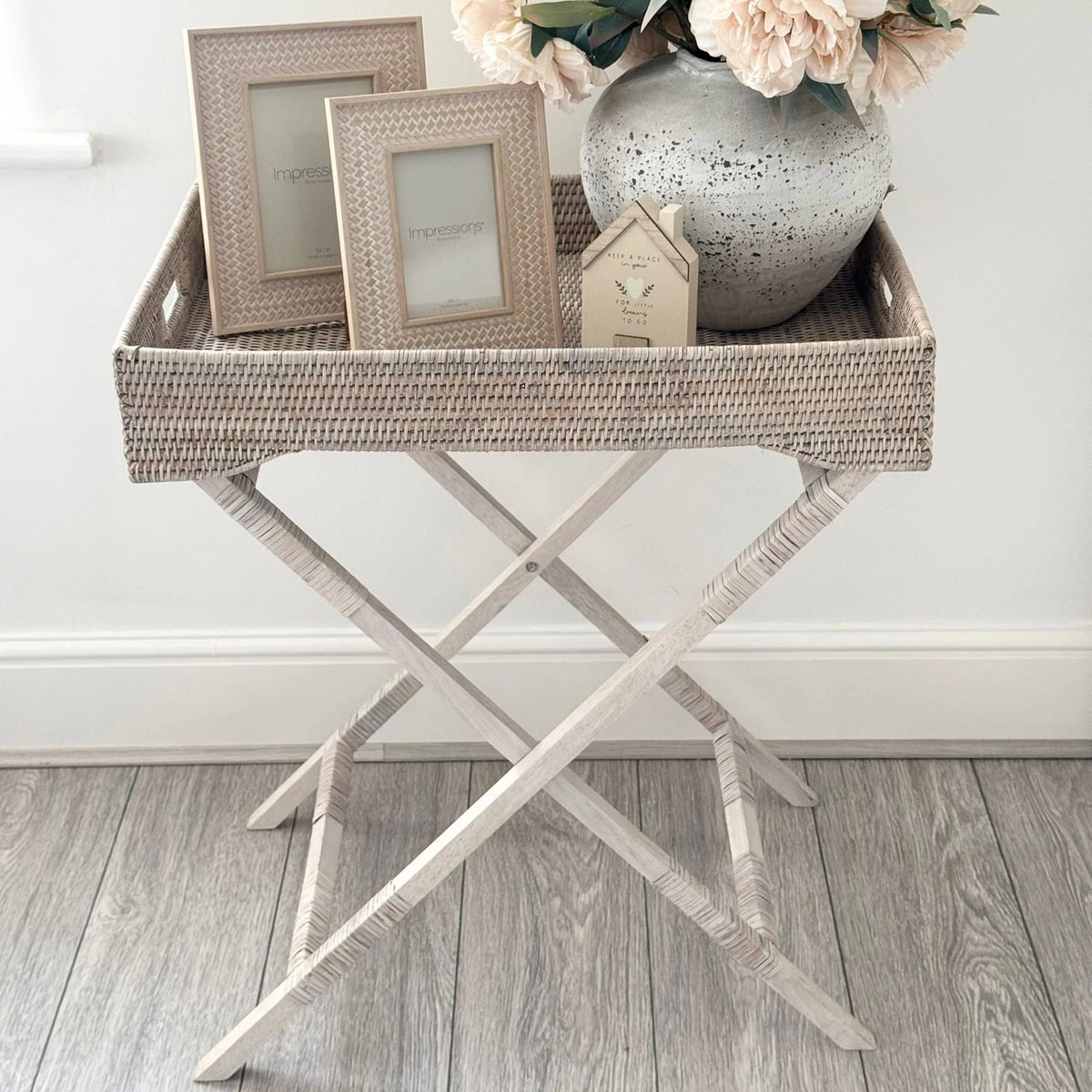 Wickham Rattan Rectangle Butler Tray Side Table, woven rectangular tray table displaying frames and a flower vase