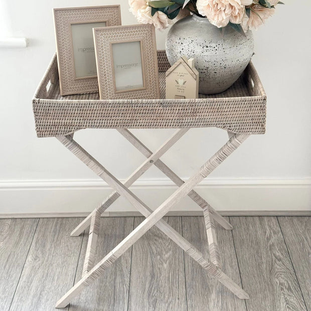 Wickham Rattan Rectangle Butler Tray Side Table, woven rectangular tray table displaying frames and a flower vase
