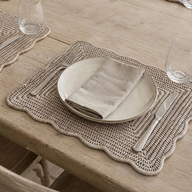 Wickham Rattan Rectangle Scalloped Placemats - Set of Two, close-up of a scalloped placemat beneath a plate and linen napkin