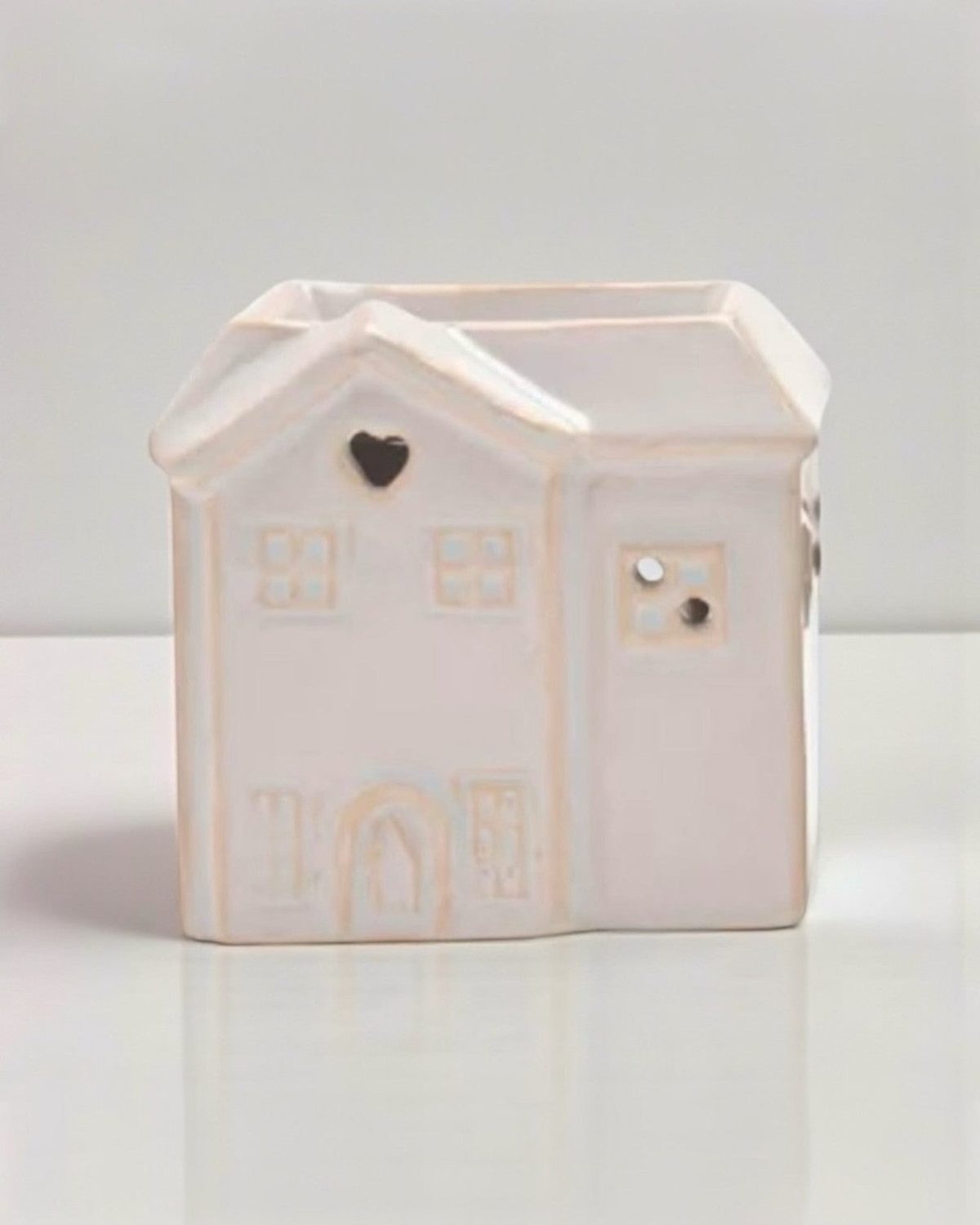 Small beige ceramic house wax burner by Widdop & Co, decorative home fragrance accessory with a cozy house design.