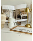 Widdop & Co LED touch desk lamp in gold with a medium-sized adjustable lighting base on a desk surface