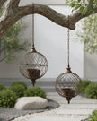 Rusty metal hanging ball planters by Wikholmform, outdoor decor with weathered textured metal design for garden display.