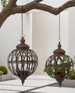 Rusty metal lattice ball planters hanging outdoors, decorative metal planter from Wikholmform with a rustic finish.