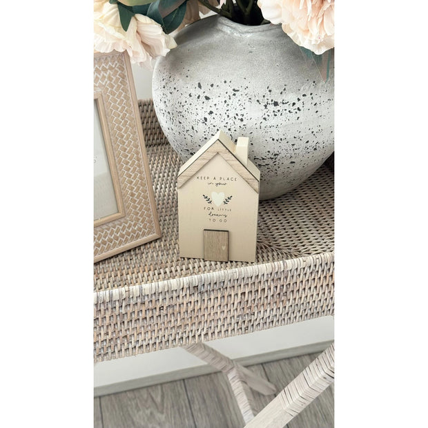 Wooden House Ornament - Beige Moments Keep A Place In Your Heart, close view of the beige house ornament beside a vase