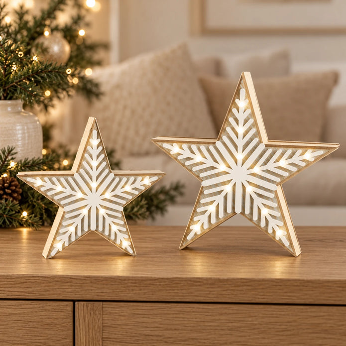 Small and medium wooden LED chevron stars illuminated together on an oak console in a neutral Christmas room.