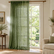 Olive green woven sheer voile curtain panel by Riva Home hanging in a stylish living room window.